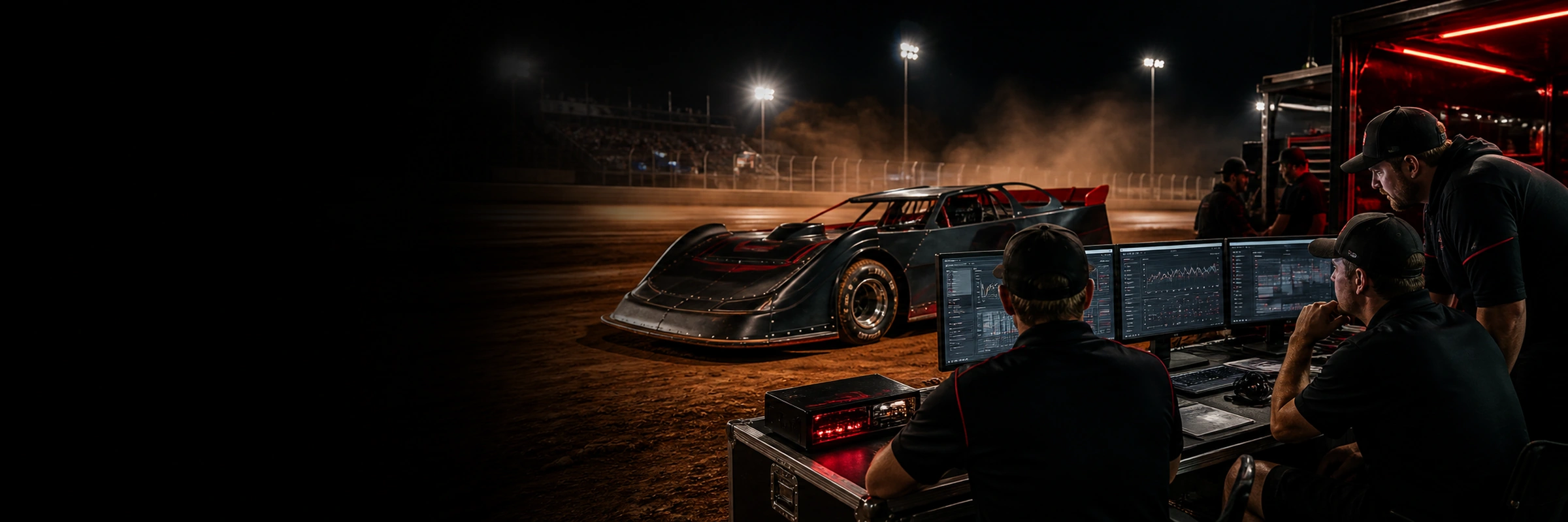 Dirt late model and race operations crew working beside a clay oval at night.